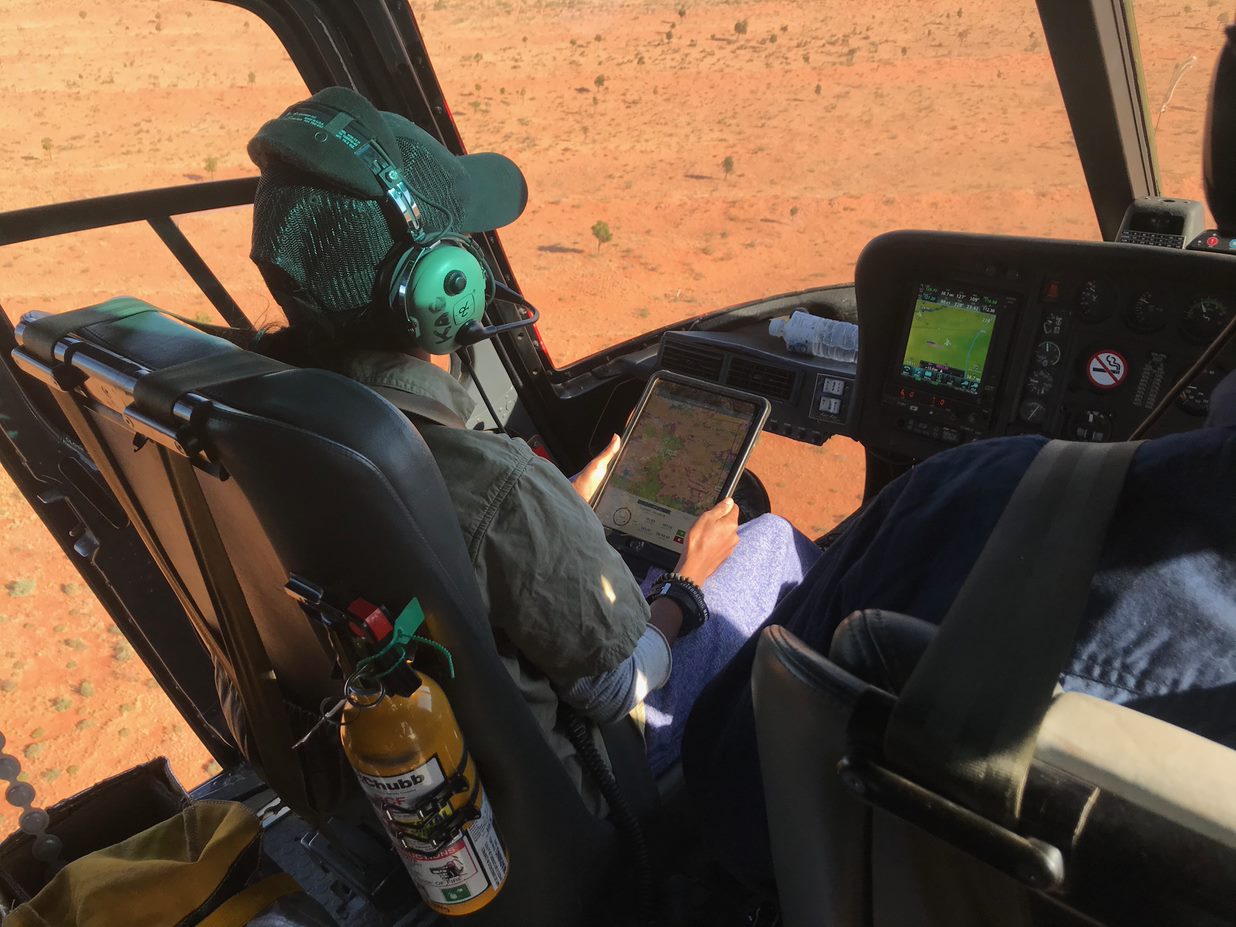 Female ranger sitting in helicopter cockpit.